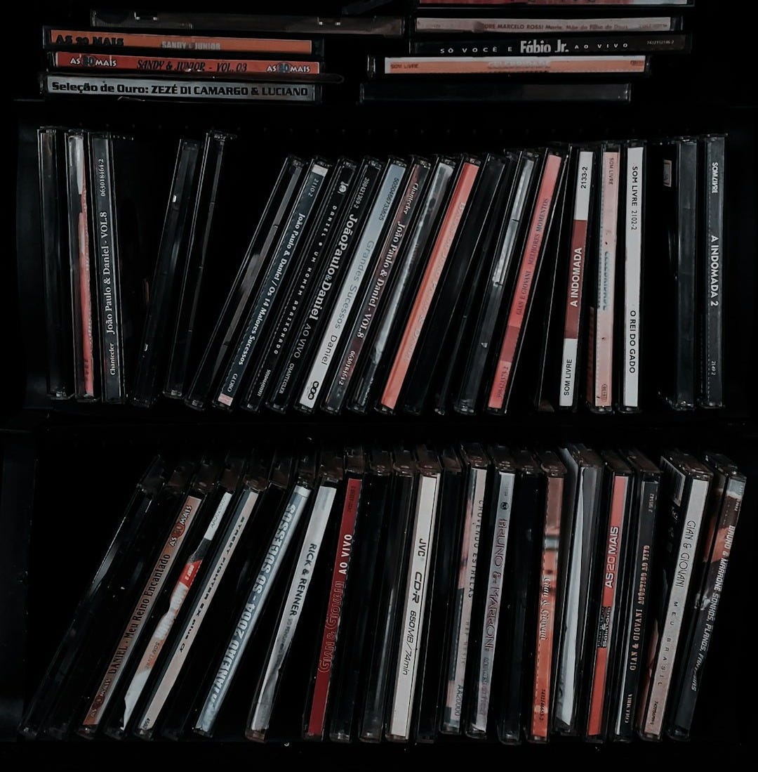 a black shelf with a bunch of cds on it a black shelf with a bunch of cds on it