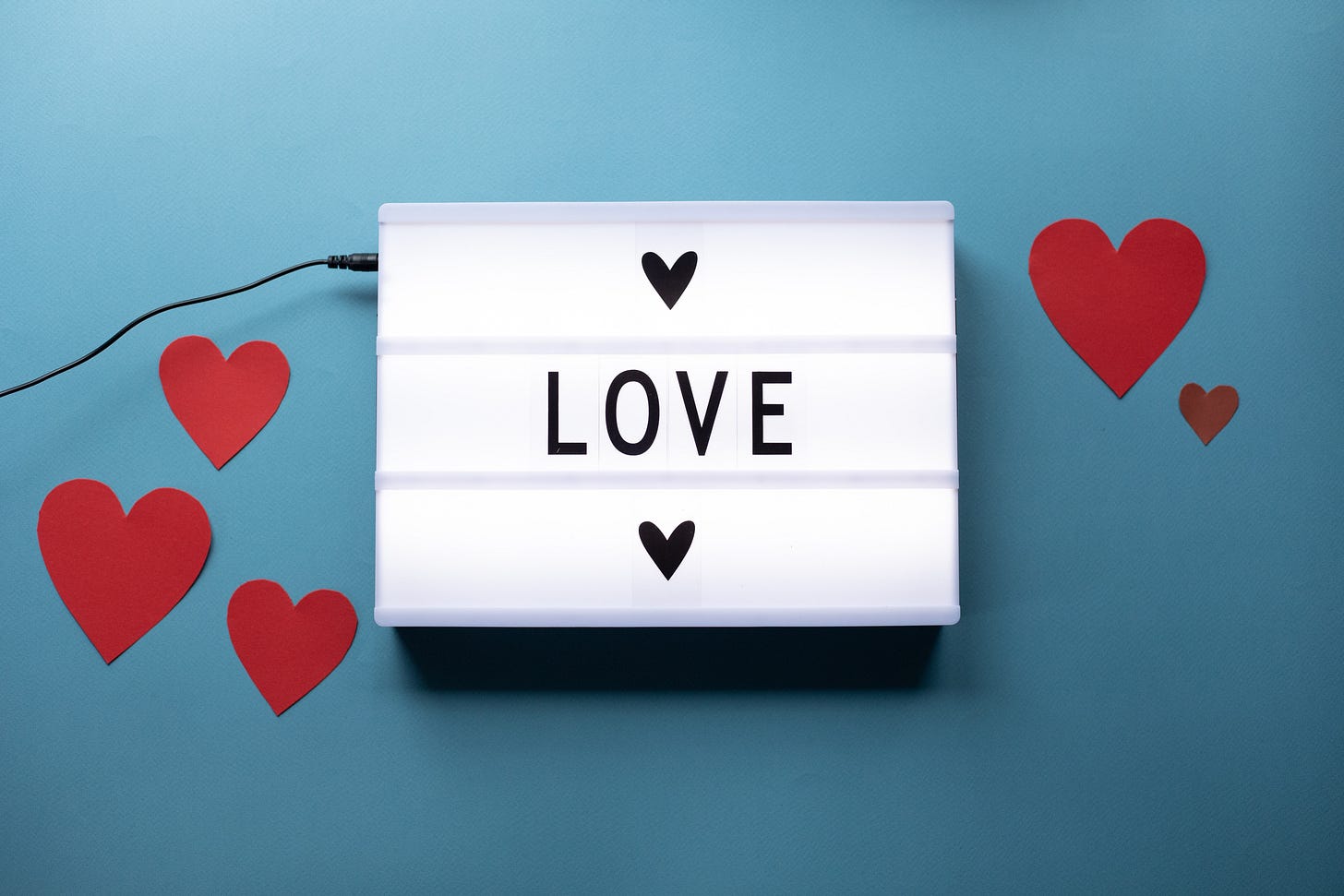 A sign that says "Love" surrounded by hearts.