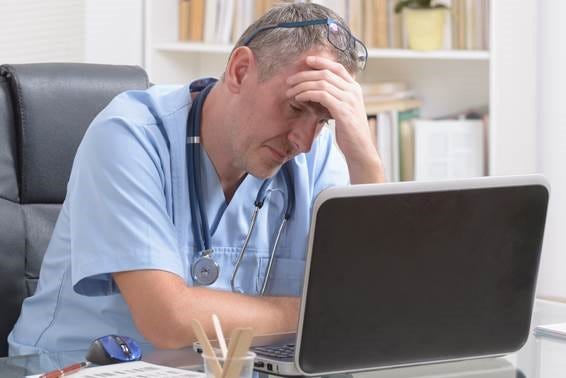 A doctor seated at his desk, focused on his laptop, surrounded by medical books and a stethoscope. A doctor seated at his desk, focused on his laptop, surrounded by medical books and a stethoscope.