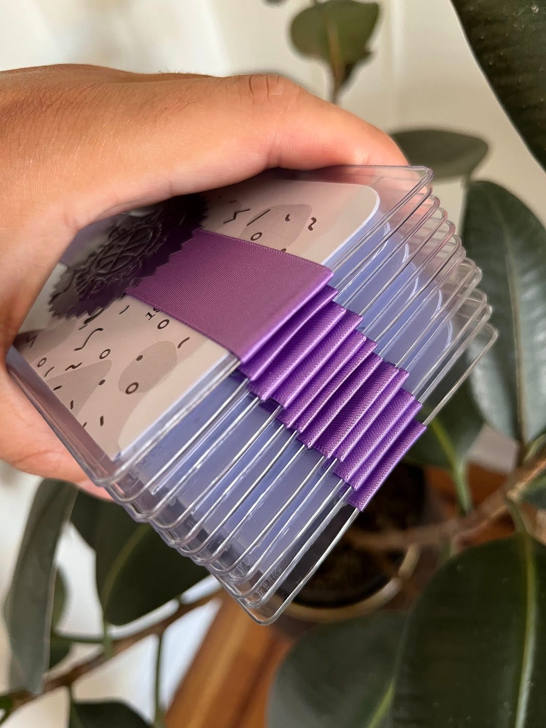 Hand holding stack of packaged zines