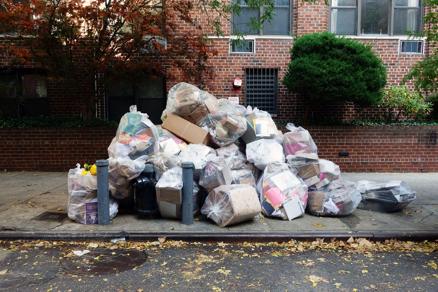 A pile of trash bags on a sidewalk in New York City