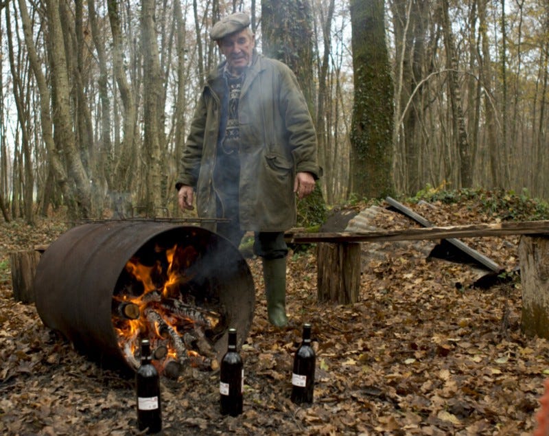 A man tending to a bonfire in a barrel. A man tending to a bonfire in a barrel.