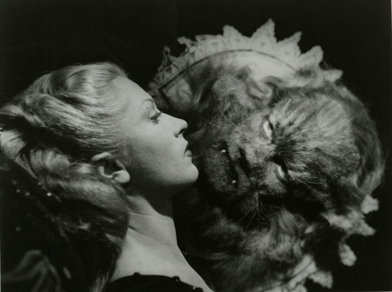 Black and white phorograph showing a blonde-haired woman in profile, facing a hairy beast in the shape of a man Black and white phorograph showing a blonde-haired woman in profile, facing a hairy beast in the shape of a man