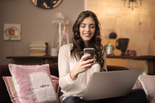 Foto de Andrea Piacquadio de Pexels: https://www.pexels.com/es-es/foto/mujer-sentada-en-el-sofa-mientras-mira-el-telefono-con-el-portatil-en-el-regazo-920382/