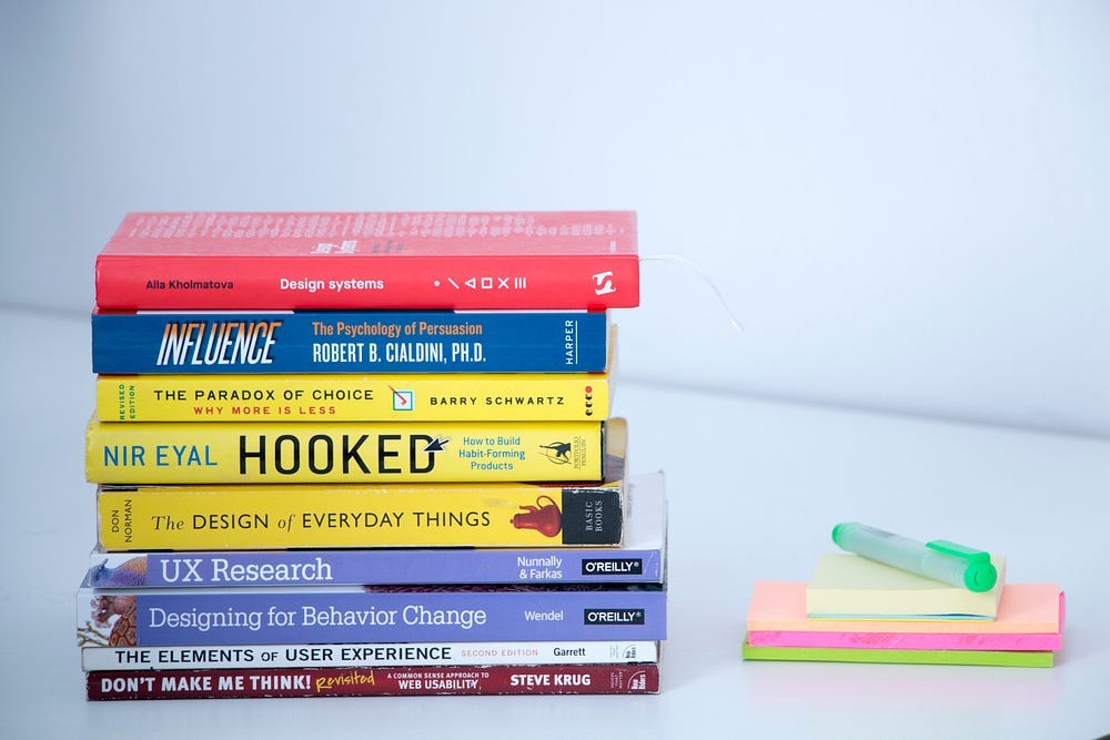 Stack of leadership books on the left. Small stack of post-its on the right. Stack of leadership books on the left. Small stack of post-its on the right.