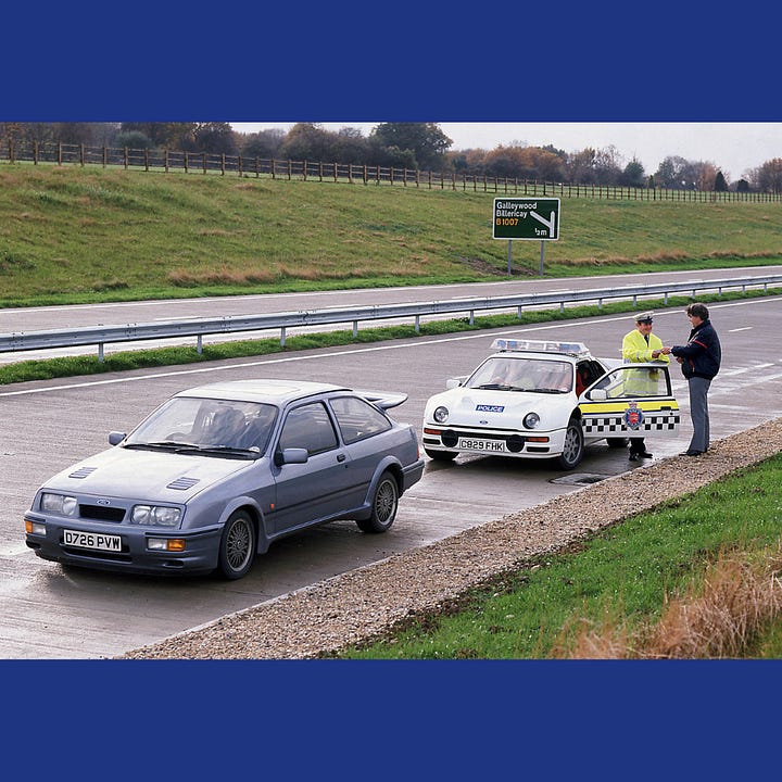 The RS200 'stops' a Cosworth Sierra in a layby on the A12.