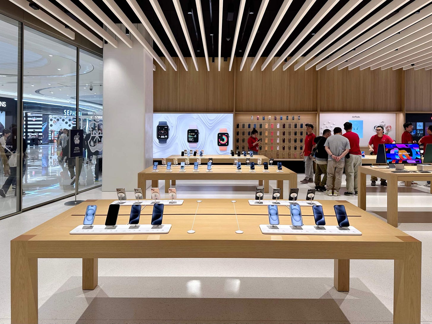 The interior of Apple MixC Wenzhou near the store entrance. iPhones are displayed on a table in the foreground. The interior of Apple MixC Wenzhou near the store entrance. iPhones are displayed on a table in the foreground.