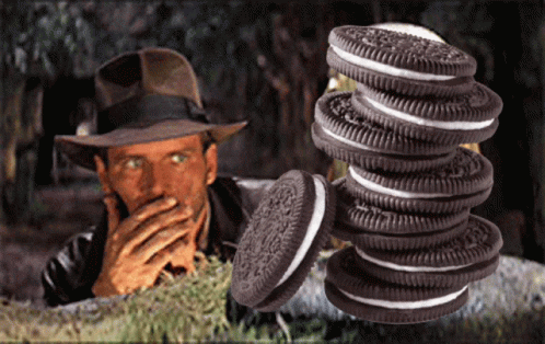 a man in a hat is covering his mouth behind a stack of oreos