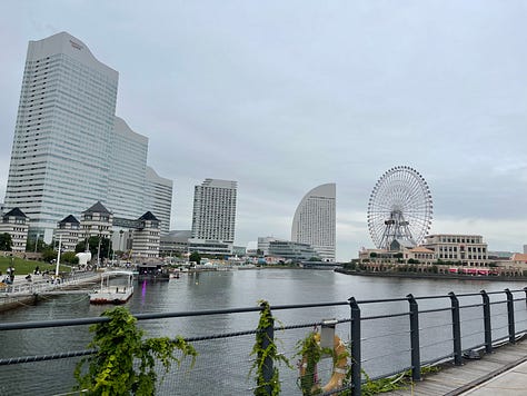 A collage of nine photos from travels in Japan: two sumo wrestlers posing with visitors; vintage kabuki posters on display; a small group sitting on tatami mats during a cultural workshop; a mannequin dressed in a traditional kimono with floral patterns; three people smiling in front of a lantern-filled temple gate; a night market vendor grilling skewers and takoyaki; two friends taking a selfie in Shibuya among bright city signs; the waterfront skyline and Ferris wheel in Yokohama; and a narrow alleyway in Kyoto lined with glowing izakaya lanterns.