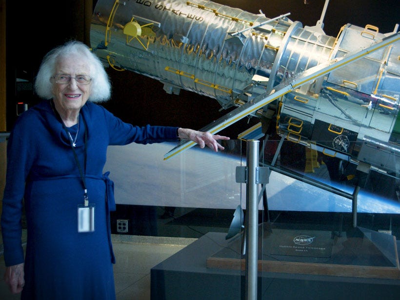 Nancy Grace Roman stands in front of a scale model of the Hubble Space Telescope