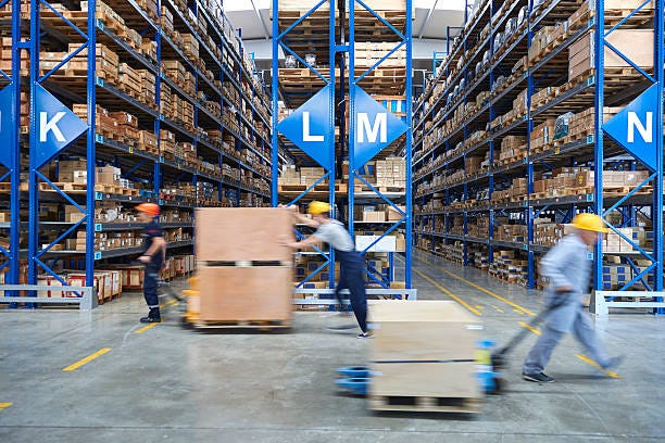 Coworkers carrying cardboard box in warehouse. Cardboard boxes on shelves in warehouse. Storhouse. retail warehouse stock pictures, royalty-free photos & images