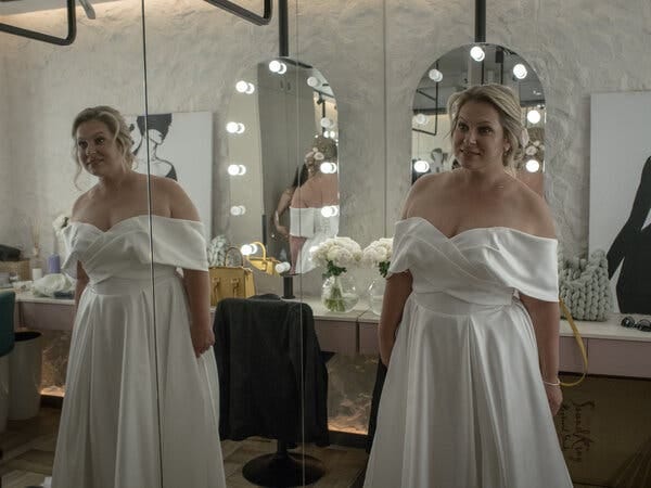 The bride checks her appearance in a mirrored room. 