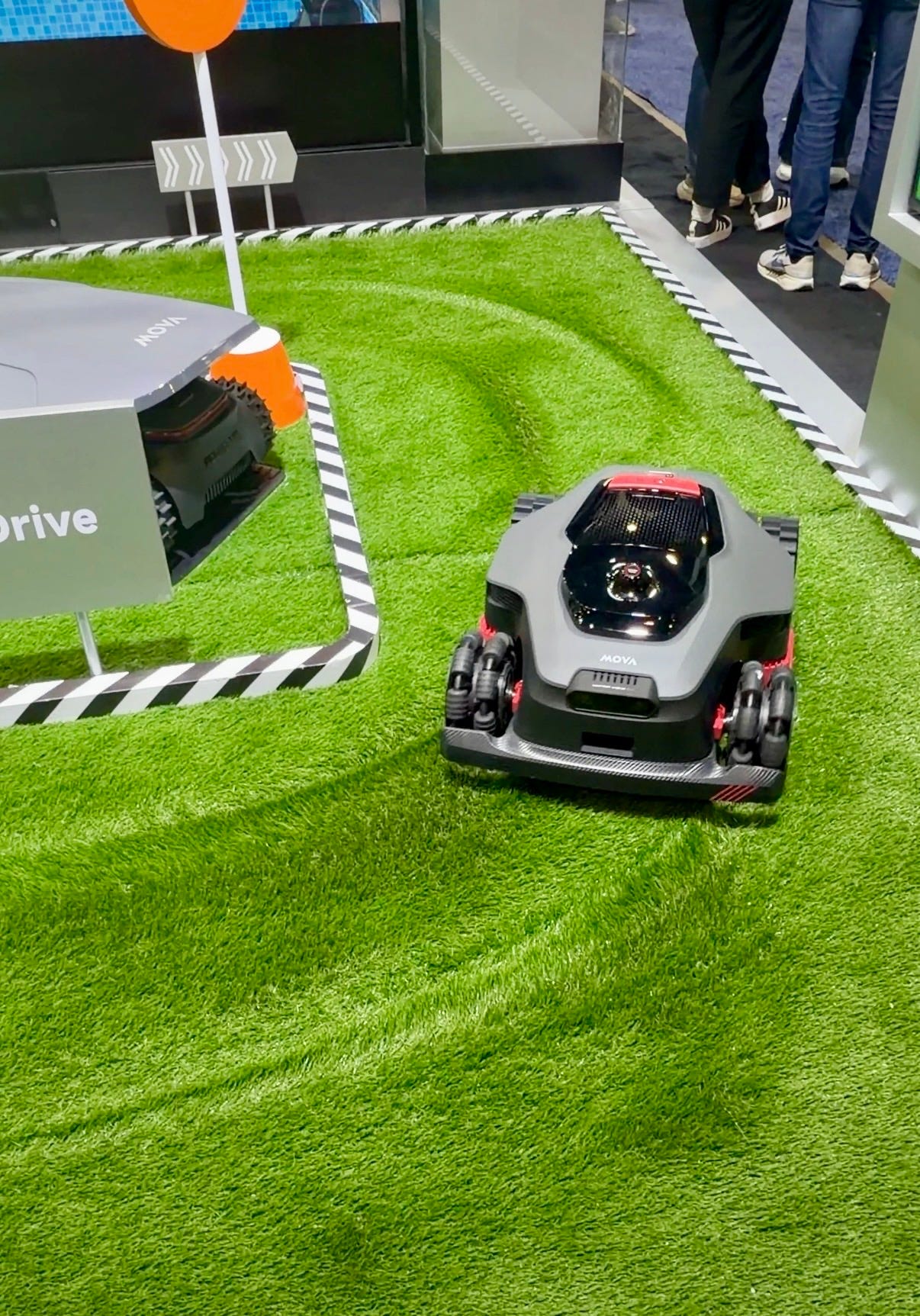 A robotic lawnmower drives across a patch of artificial grass in a CES demo area, showing its ability to navigate and avoid obstacles. A robotic lawnmower drives across a patch of artificial grass in a CES demo area, showing its ability to navigate and avoid obstacles.