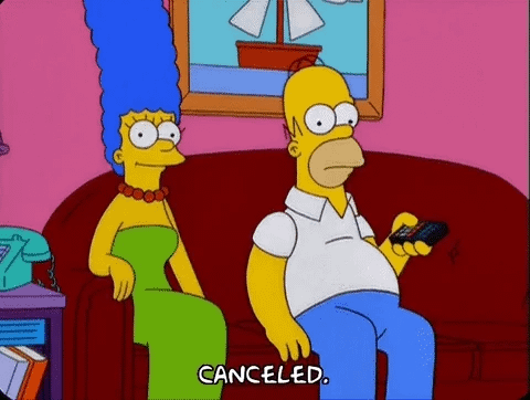 Homer and Marge Simpson on the sofa waching TV, Homer is pressing the remote saying: "canceled"