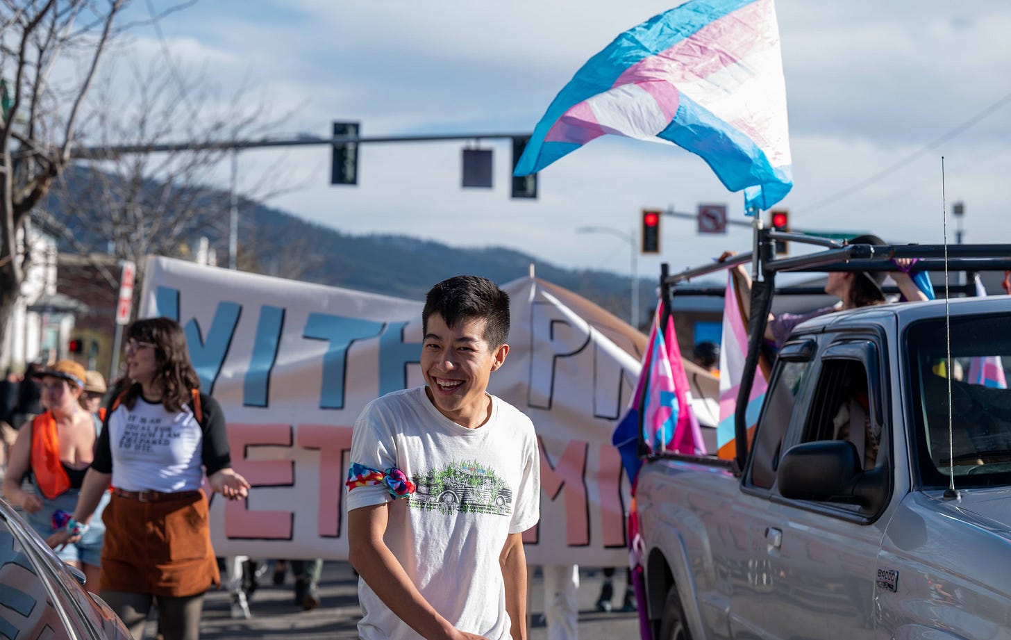 man in white t-shirt in parade moving down street
