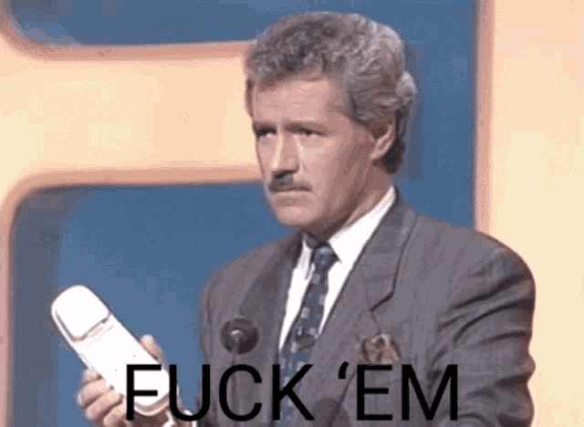 a man in a suit and tie is holding a cell phone with the words fuck em written on it