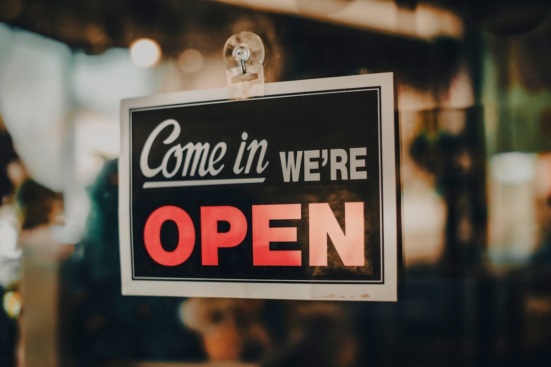 Free Charming open sign displayed at a shop, inviting customers inside a welcoming retail environment. Stock Photo