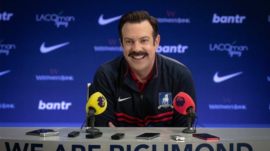 Ted Lasso speaks at a press conference. Ted Lasso speaks at a press conference.
