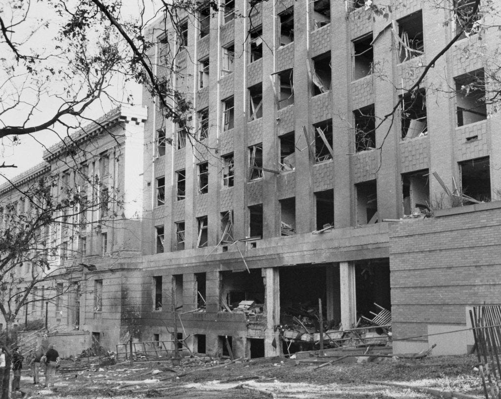 black and white photo of Sterling Hall after the bombing shows a building with windows blown out and obvious damage. black and white photo of Sterling Hall after the bombing shows a building with windows blown out and obvious damage.