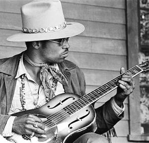 Left image: Album cover for Little Richard's 'The Rill Thing' features Richard onstage, his face covered in sweat and backlit. Photo on right is Taj Mahal playing in a hat, seated, playing a steel guitar.