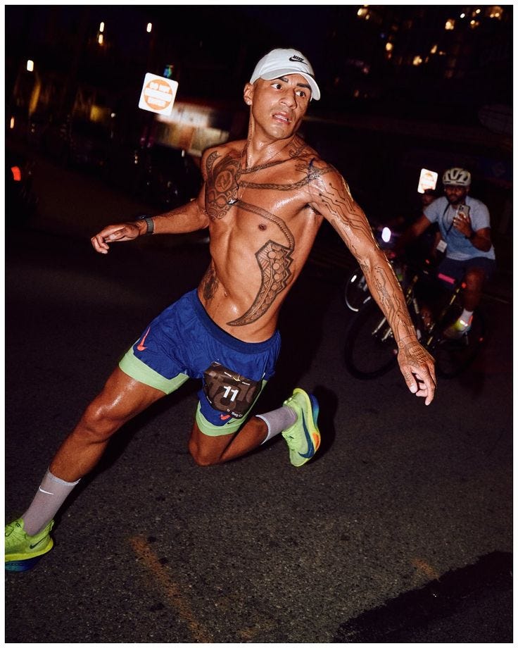 This may contain: a shirtless man running in the street at night
