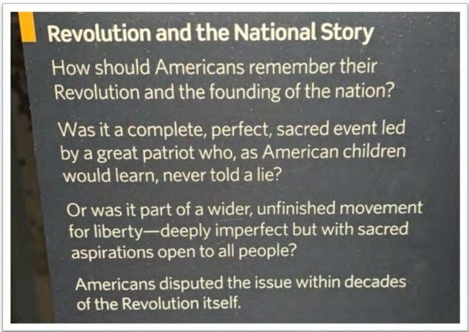 Sign introducing an exhibit on American Democracy, reading 'Revolution and the National Story: How should Americans remember their Revolution and the founding of the nation? Was it a complete, perfect, sacred event led by a great patriot, who as American children would learn, never told a lie? Or was it part of a wider, unfinished movement for liberty — deeply imperfect but with sacred aspirations open to all people? Americans disputed the issue within decades of the Revolution Itself.' Sign introducing an exhibit on American Democracy, reading 'Revolution and the National Story: How should Americans remember their Revolution and the founding of the nation? Was it a complete, perfect, sacred event led by a great patriot, who as American children would learn, never told a lie? Or was it part of a wider, unfinished movement for liberty — deeply imperfect but with sacred aspirations open to all people? Americans disputed the issue within decades of the Revolution Itself.'