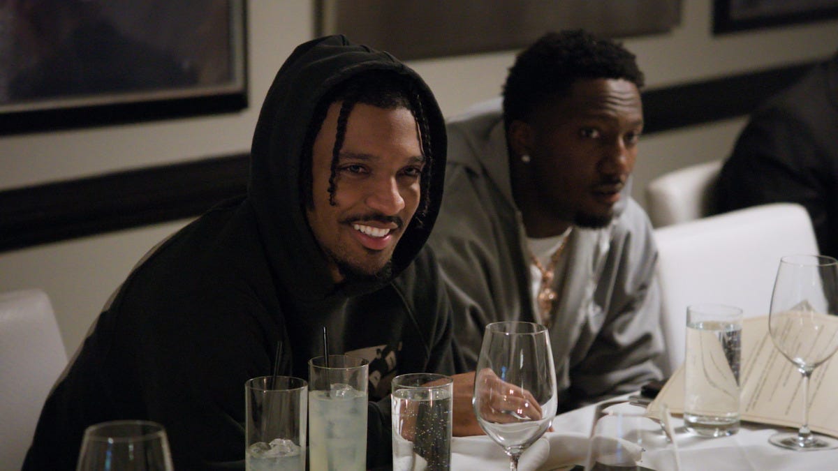 Jayden Daniels and a friend are sitting at a table full of glasses.