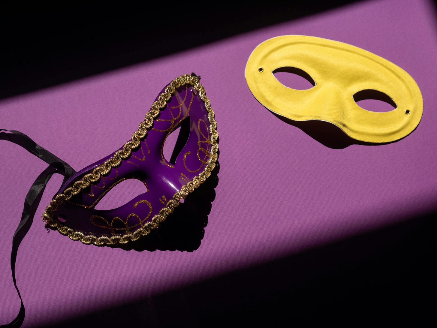 Yellow and purple masquerade masks on purple background Yellow and purple masquerade masks on purple background