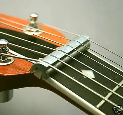 Some examples of round neck guitars modified with a nut riser