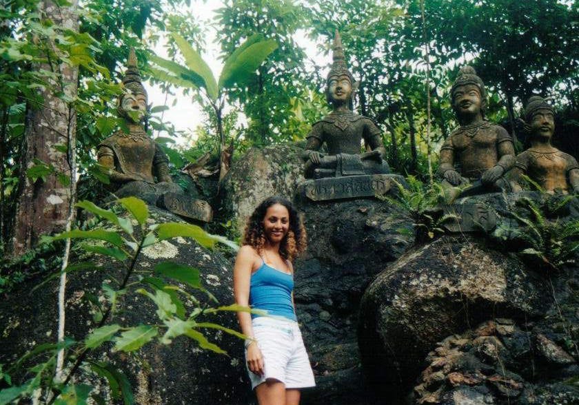 A young woman stand among ancient Thai sculptures in Magic Garden on Koh Samui.