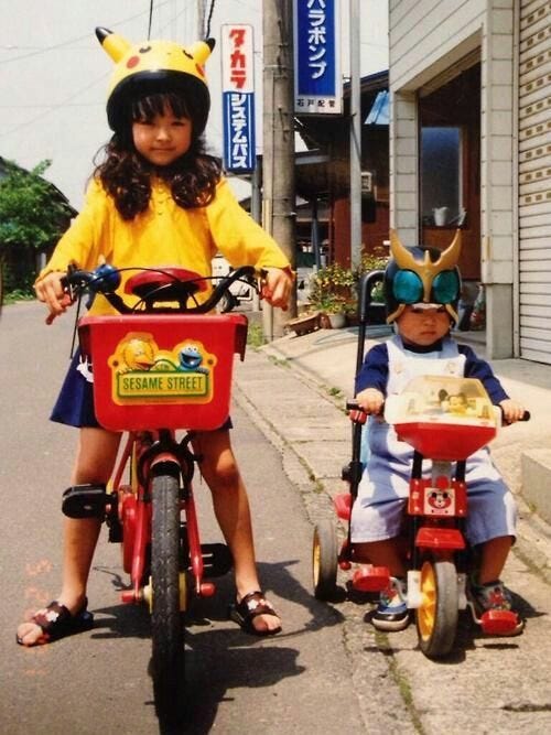 This may contain: two children are riding bikes down the street