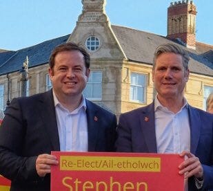 Two men holding a sign in front of a building

AI-generated content may be incorrect.