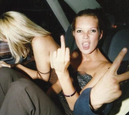 This may contain: two young women sitting in the back seat of a car, one pointing at the camera This may contain: two young women sitting in the back seat of a car, one pointing at the camera
