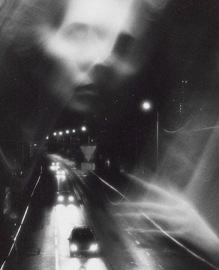 This may contain: a blurry photo of cars driving down a street at night time, with one person's head in the distance