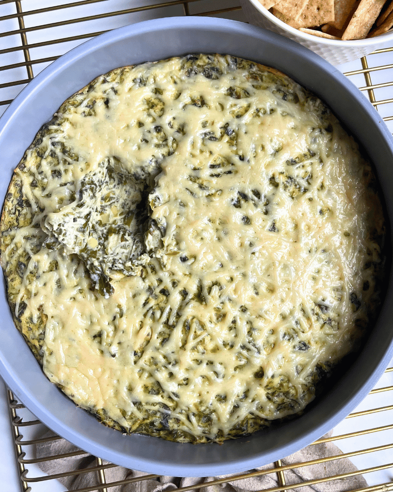 vegan spinach artichoke dip with a missing bite in the middle