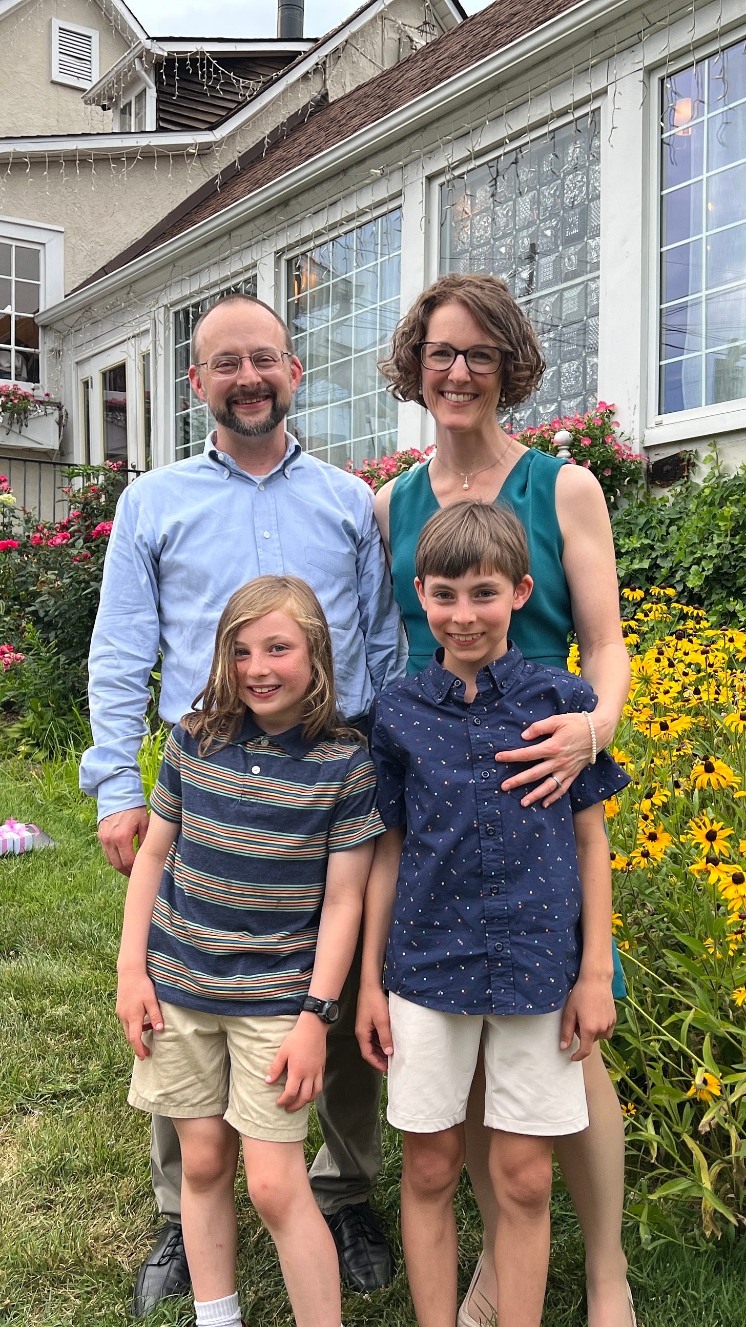 Jennifer Anderson, her husband, and two kids outside surrounded by wild flowers