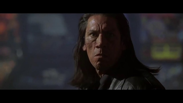 Danny Trejo appears intense and battle-worn in a dark, smoke-filled setting from The Replacement Killers.