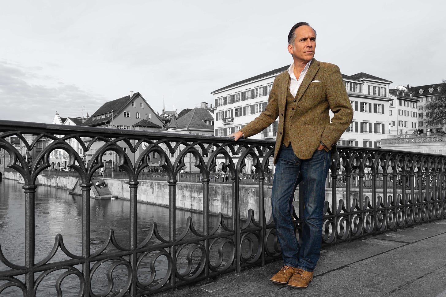 Martin Grassberger steht auf der Münsterbrücke in Zürich, den Blick nachdenklich in die Ferne gerichtet. Der Hintergrund mit Limmat, Häusern und Brückengeländer ist schwarz-weiss, während Grassberger farbig hervorgehoben ist. Martin Grassberger steht auf der Münsterbrücke in Zürich, den Blick nachdenklich in die Ferne gerichtet. Der Hintergrund mit Limmat, Häusern und Brückengeländer ist schwarz-weiss, während Grassberger farbig hervorgehoben ist.