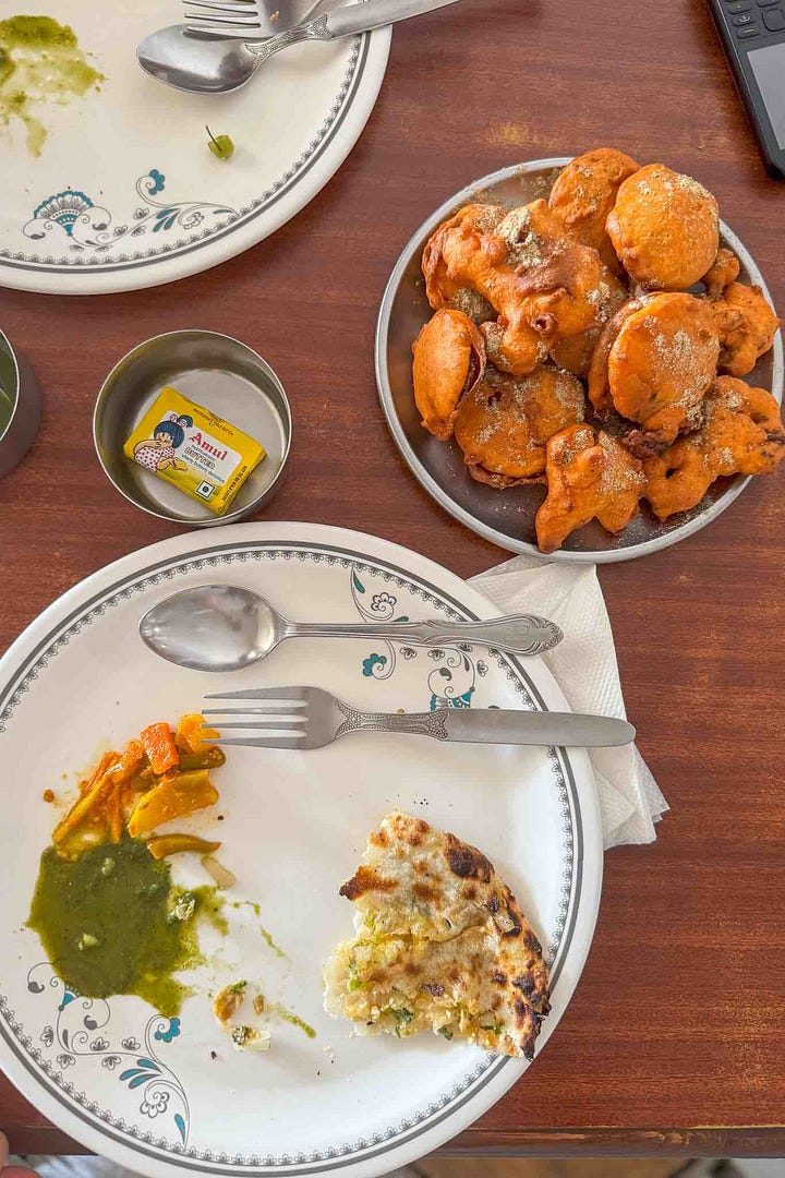 A mixed spread of vegetable pakoras and Amritsari kulcha with pickles and coriander mint chutney