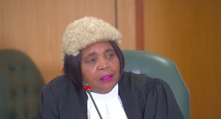 Zimbabwean lwayer wearinga white wig on her black wig.