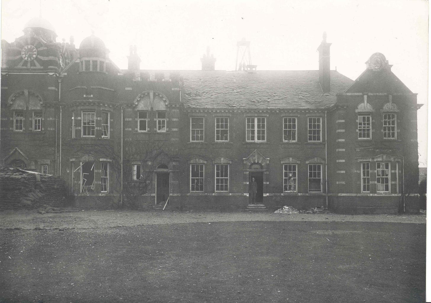 A two storey Victorian-era HQ block. All windows are smashed, roof tiles are missing or misaligned and wooden framings are either damaged or destroyed.