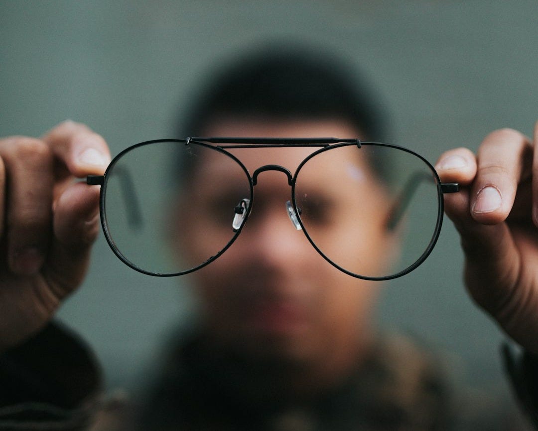 man holding eyeglasses man holding eyeglasses