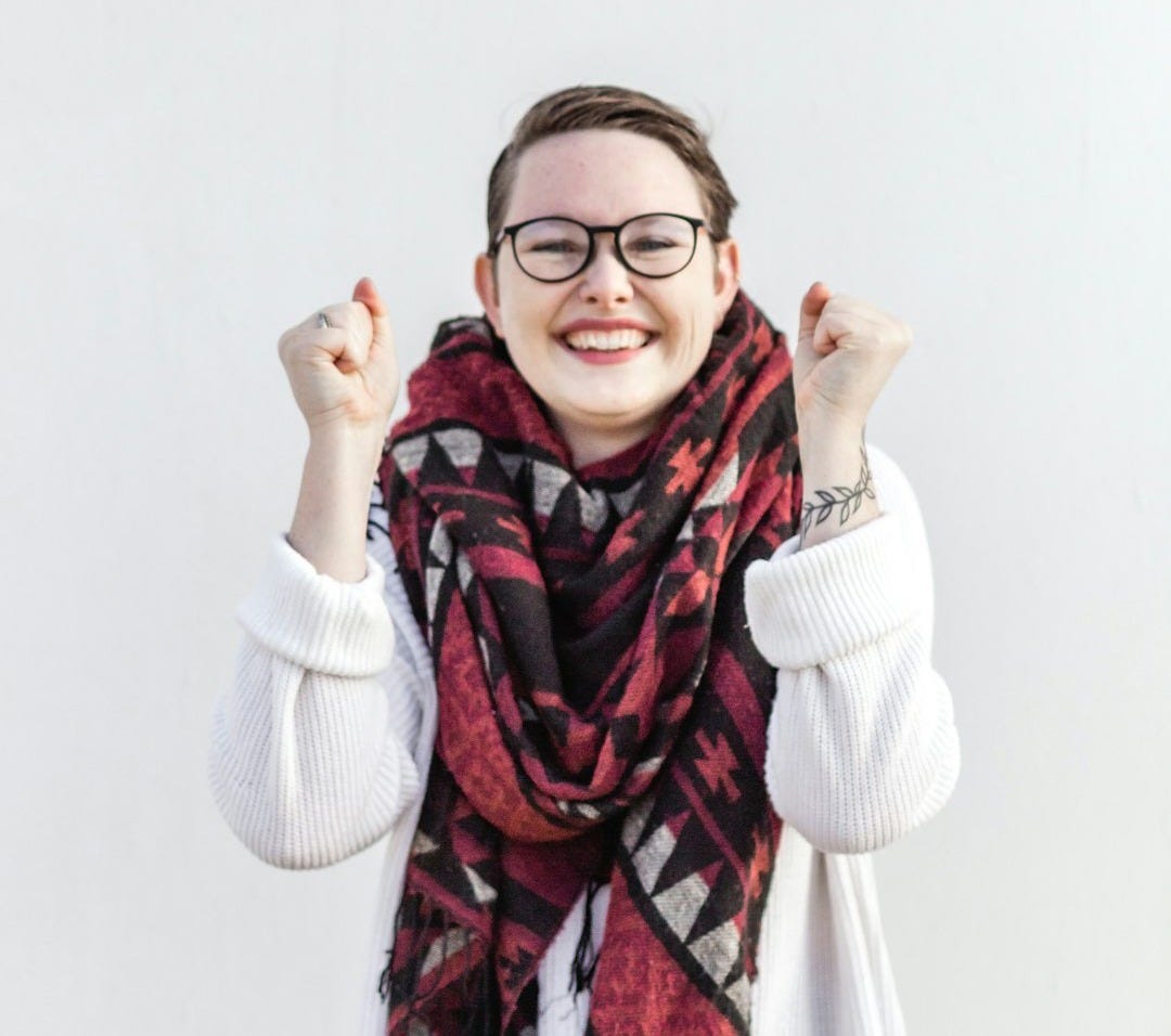 woman in white sweater wearing red scarf and black framed eyeglasses