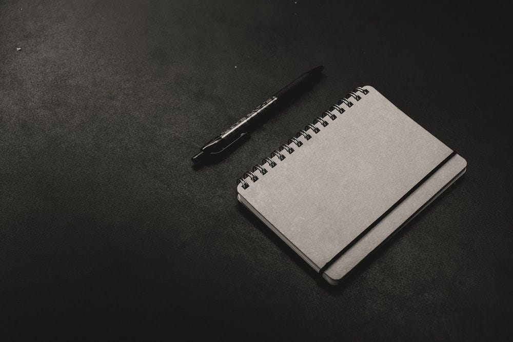 black click pen beside notebook