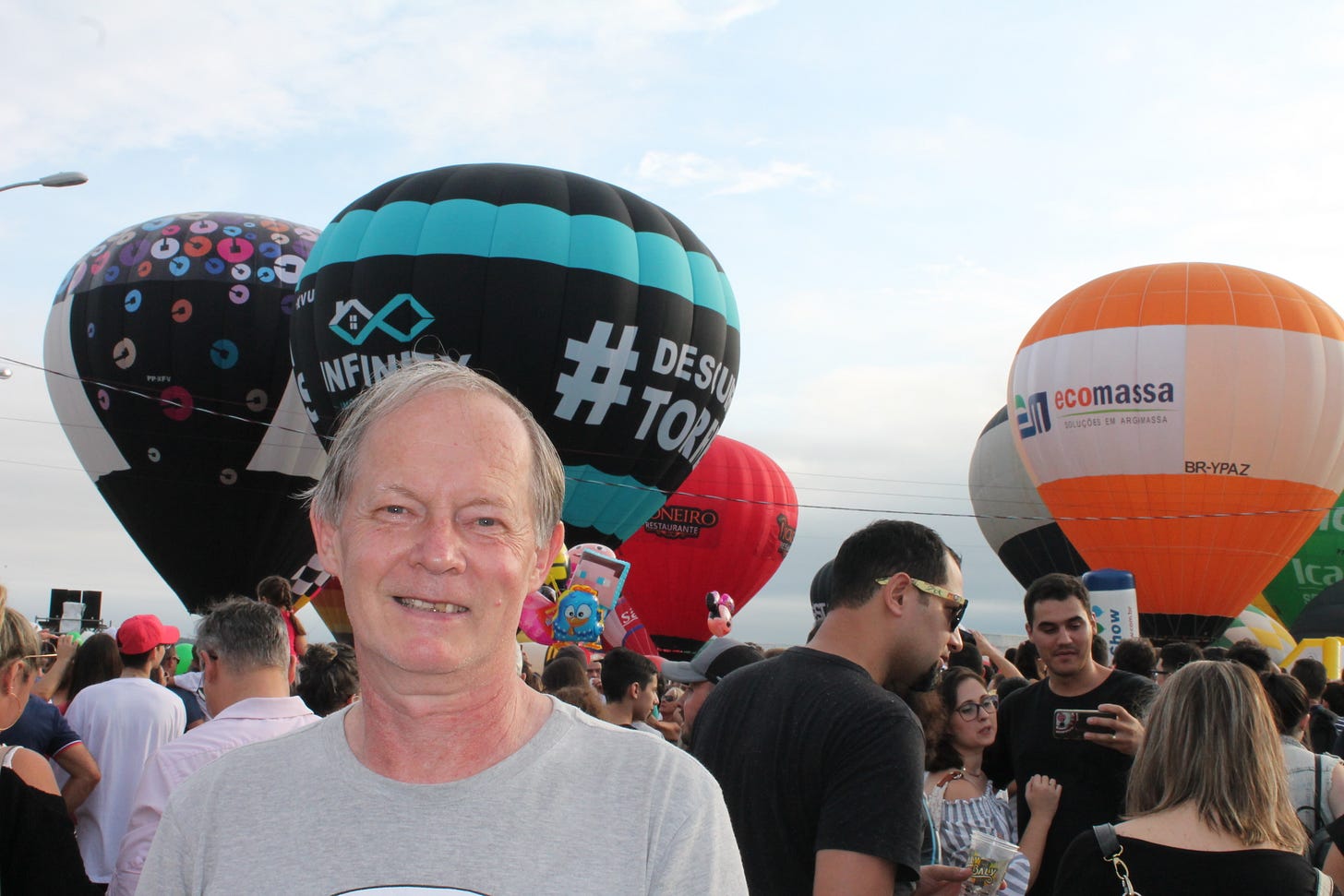 Foto do meu pai sorrindo com vários balões atrás
