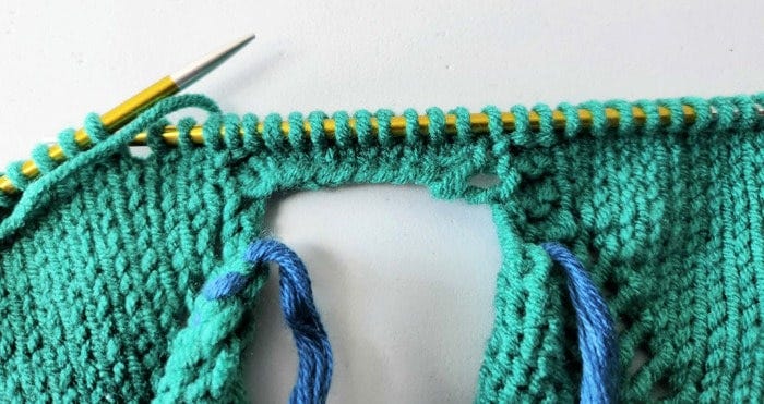 Realizing I'd not placed the correct stitches on the scrap yarn for the sleeves nor on the needle to continue knitting the body. I was missing a garter stitch on one side of the picked up underarm stitches