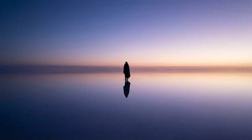 A person standing in a vast, calm landscape where the horizon disappears into a soft, endless sky A person standing in a vast, calm landscape where the horizon disappears into a soft, endless sky