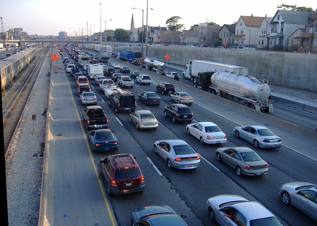 Daytime scene of bumper to bumper highway traffic, stretching to the horizon.