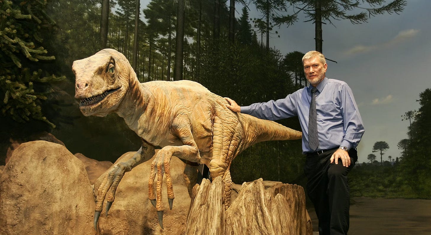 Ken Ham poses with dinosaur in a diarama at the Creation Museum.