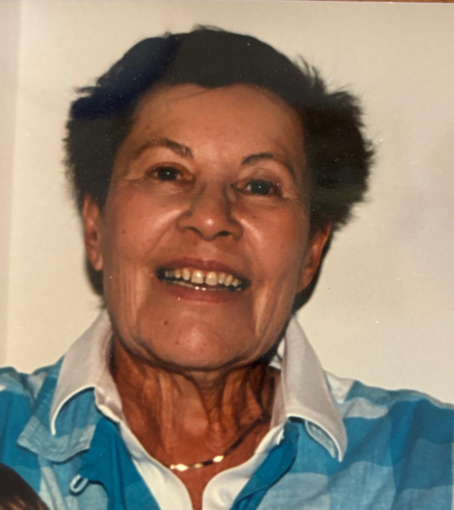 Photo of Etta Levy: She has short brown hair, and smiles at the camera